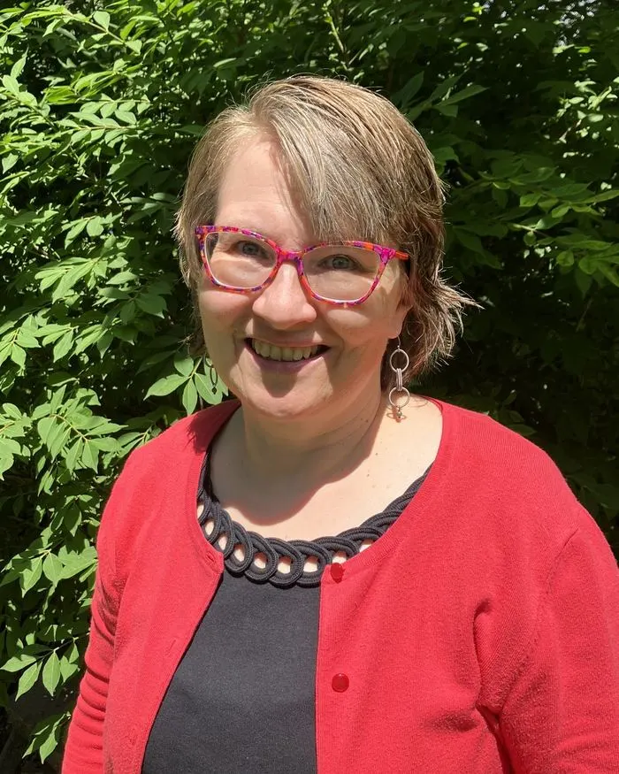 Cindy Hodgson, smiling, outdoors in summer daylight